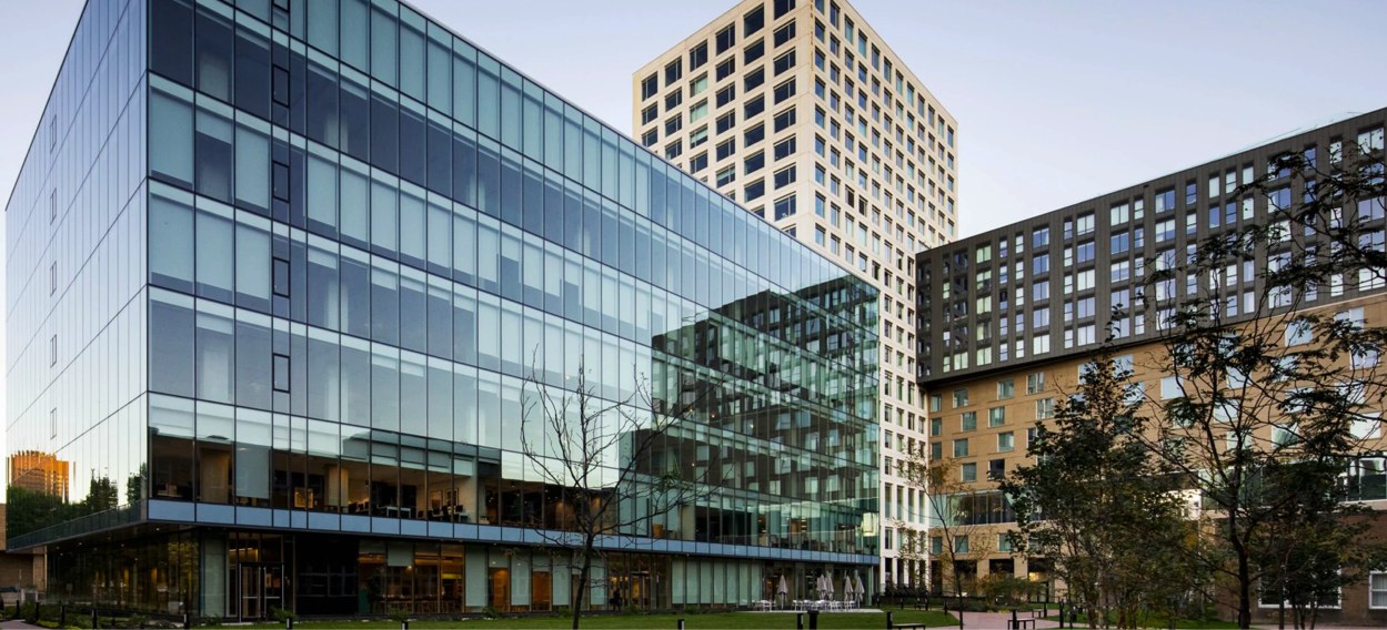 A glass office building beside residential towers at Gare Viger